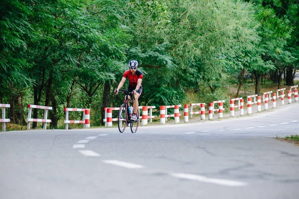 KHARKIV, UKRAINE - 2 Ağustos 2020 Demir Adam yarışması sırasında triatoncu bisikletli triatloncu bisikleti. Üç takım elbiseli ve kasklı bir bisiklet sporcusu. Halka açık etkinliklere izin var. CV salgını sırasında Avrupa sporu.