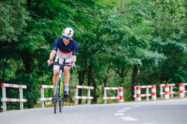 KHARKIV, UKRAINE - 2 Ağustos 2020 Demir Adam yarışması sırasında triatoncu bisikletli triatloncu bisikleti. Üç takım elbiseli ve kasklı bir bisiklet sporcusu. Halka açık etkinliklere izin var. CV salgını sırasında Avrupa sporu.