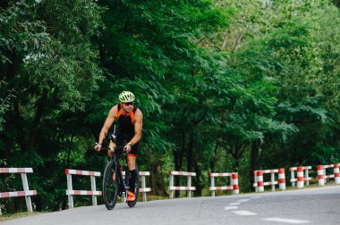 KHARKIV, UKRAINE - 2 Ağustos 2020 Demir Adam yarışması sırasında triatoncu bisikletli triatloncu bisikleti. Üç takım elbiseli ve kasklı bir bisiklet sporcusu. Halka açık etkinliklere izin var. CV salgını sırasında Avrupa sporu.