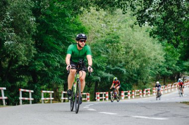KHARKIV, UKRAINE - 2 Ağustos 2020 Demir Adam yarışması sırasında triatoncu bisikletli triatloncu bisikleti. Üç takım elbiseli ve kasklı bir bisiklet sporcusu. Halka açık etkinliklere izin var. CV salgını sırasında Avrupa sporu.