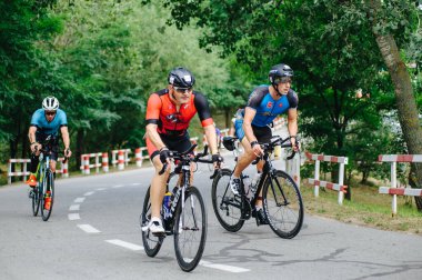 KHARKIV, UKRAINE - 2 Ağustos 2020 Demir Adam yarışması sırasında triatoncu bisikletli triatloncu bisikleti. Üç takım elbiseli ve kasklı bir bisiklet sporcusu. Halka açık etkinliklere izin var. CV salgını sırasında Avrupa sporu.