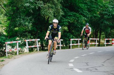 KHARKIV, UKRAINE - 2 Ağustos 2020 Demir Adam yarışması sırasında triatoncu bisikletli triatloncu bisikleti. Üç takım elbiseli ve kasklı bir bisiklet sporcusu. Halka açık etkinliklere izin var. CV salgını sırasında Avrupa sporu.