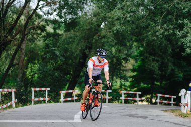 KHARKIV, UKRAINE - 2 Ağustos 2020 Demir Adam yarışması sırasında triatoncu bisikletli triatloncu bisikleti. Üç takım elbiseli ve kasklı bir bisiklet sporcusu. Halka açık etkinliklere izin var. CV salgını sırasında Avrupa sporu.