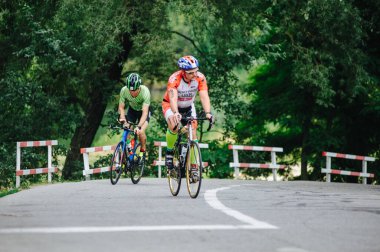 KHARKIV, UKRAINE - 2 Ağustos 2020 Demir Adam yarışması sırasında triatoncu bisikletli triatloncu bisikleti. Üç takım elbiseli ve kasklı bir bisiklet sporcusu. Halka açık etkinliklere izin var. CV salgını sırasında Avrupa sporu.