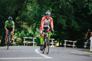 KHARKIV, UKRAINE - 2 Ağustos 2020 Demir Adam yarışması sırasında triatoncu bisikletli triatloncu bisikleti. Üç takım elbiseli ve kasklı bir bisiklet sporcusu. Halka açık etkinliklere izin var. CV salgını sırasında Avrupa sporu.