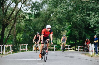 KHARKIV, UKRAINE - 2 Ağustos 2020 Demir Adam yarışması sırasında triatoncu bisikletli triatloncu bisikleti. Üç takım elbiseli ve kasklı bir bisiklet sporcusu. Halka açık etkinliklere izin var. CV salgını sırasında Avrupa sporu.