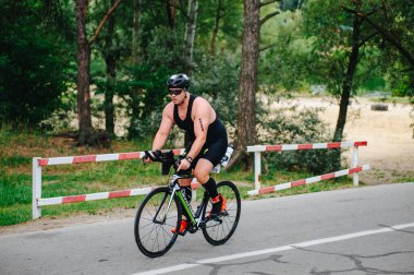 KHARKIV, UKRAINE - 2 Ağustos 2020 Demir Adam yarışması sırasında triatoncu bisikletli triatloncu bisikleti. Üç takım elbiseli ve kasklı bir bisiklet sporcusu. Halka açık etkinliklere izin var. CV salgını sırasında Avrupa sporu.