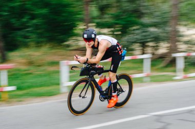 KHARKIV, UKRAINE - 2 Ağustos 2020 Demir Adam yarışması sırasında triatoncu bisikletli triatloncu bisikleti. Üç takım elbiseli ve kasklı bir bisiklet sporcusu. Halka açık etkinliklere izin var. CV salgını sırasında Avrupa sporu.