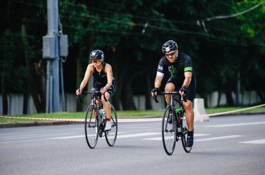 KHARKIV, UKRAINE - 2 Ağustos 2020 Demir Adam yarışması sırasında triatoncu bisikletli triatloncu bisikleti. Üç takım elbiseli ve kasklı bir bisiklet sporcusu. Halka açık etkinliklere izin var. CV salgını sırasında Avrupa sporu.