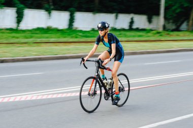 KHARKIV, UKRAINE - 2 Ağustos 2020 Demir Adam yarışması sırasında triatoncu bisikletli triatloncu bisikleti. Üç takım elbiseli ve kasklı bir bisiklet sporcusu. Halka açık etkinliklere izin var. CV salgını sırasında Avrupa sporu.