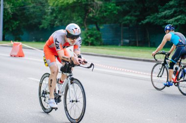 KHARKIV, UKRAINE - 2 Ağustos 2020 Demir Adam yarışması sırasında triatoncu bisikletli triatloncu bisikleti. Üç takım elbiseli ve kasklı bir bisiklet sporcusu. Halka açık etkinliklere izin var. CV salgını sırasında Avrupa sporu.