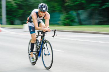 KHARKIV, UKRAINE - 2 Ağustos 2020 Demir Adam yarışması sırasında triatoncu bisikletli triatloncu bisikleti. Üç takım elbiseli ve kasklı bir bisiklet sporcusu. Halka açık etkinliklere izin var. CV salgını sırasında Avrupa sporu.