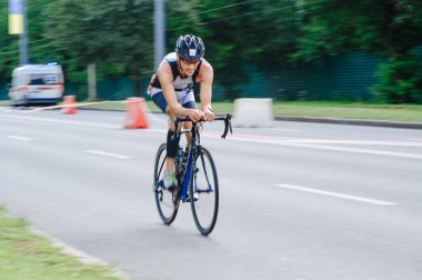 KHARKIV, UKRAINE - 2 Ağustos 2020 Demir Adam yarışması sırasında triatoncu bisikletli triatloncu bisikleti. Üç takım elbiseli ve kasklı bir bisiklet sporcusu. Halka açık etkinliklere izin var. CV salgını sırasında Avrupa sporu.