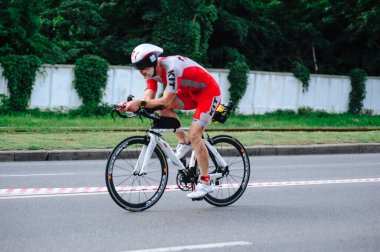 KHARKIV, UKRAINE - 2 Ağustos 2020 Demir Adam yarışması sırasında triatoncu bisikletli triatloncu bisikleti. Üç takım elbiseli ve kasklı bir bisiklet sporcusu. Halka açık etkinliklere izin var. CV salgını sırasında Avrupa sporu.