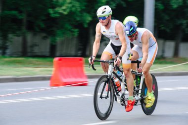 KHARKIV, UKRAINE - 2 Ağustos 2020 Demir Adam yarışması sırasında triatoncu bisikletli triatloncu bisikleti. Üç takım elbiseli ve kasklı bir bisiklet sporcusu. Halka açık etkinliklere izin var. CV salgını sırasında Avrupa sporu.