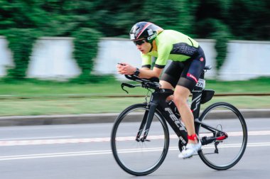 KHARKIV, UKRAINE - 2 Ağustos 2020 Demir Adam yarışması sırasında triatoncu bisikletli triatloncu bisikleti. Üç takım elbiseli ve kasklı bir bisiklet sporcusu. Halka açık etkinliklere izin var. CV salgını sırasında Avrupa sporu.