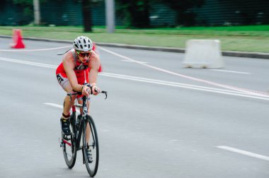 KHARKIV, UKRAINE - 2 Ağustos 2020 Demir Adam yarışması sırasında triatoncu bisikletli triatloncu bisikleti. Üç takım elbiseli ve kasklı bir bisiklet sporcusu. Halka açık etkinliklere izin var. CV salgını sırasında Avrupa sporu.
