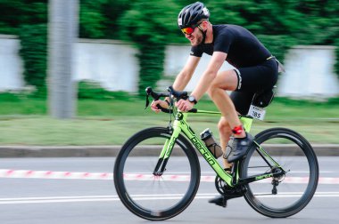 KHARKIV, UKRAINE - 2 Ağustos 2020 Demir Adam yarışması sırasında triatoncu bisikletli triatloncu bisikleti. Üç takım elbiseli ve kasklı bir bisiklet sporcusu. Halka açık etkinliklere izin var. CV salgını sırasında Avrupa sporu.