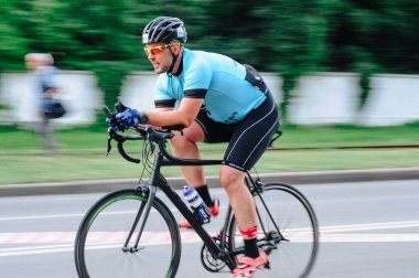 KHARKIV, UKRAINE - 2 Ağustos 2020 Demir Adam yarışması sırasında triatoncu bisikletli triatloncu bisikleti. Üç takım elbiseli ve kasklı bir bisiklet sporcusu. Halka açık etkinliklere izin var. CV salgını sırasında Avrupa sporu.