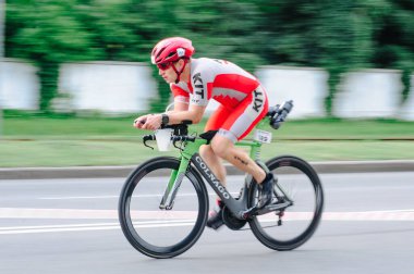 KHARKIV, UKRAINE - 2 Ağustos 2020 Demir Adam yarışması sırasında triatoncu bisikletli triatloncu bisikleti. Üç takım elbiseli ve kasklı bir bisiklet sporcusu. Halka açık etkinliklere izin var. CV salgını sırasında Avrupa sporu.