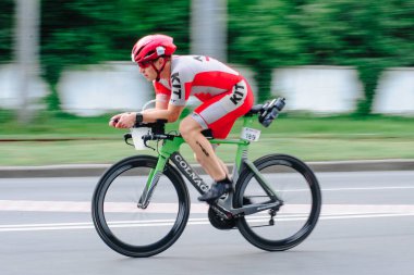 KHARKIV, UKRAINE - 2 Ağustos 2020 Demir Adam yarışması sırasında triatoncu bisikletli triatloncu bisikleti. Üç takım elbiseli ve kasklı bir bisiklet sporcusu. Halka açık etkinliklere izin var. CV salgını sırasında Avrupa sporu.