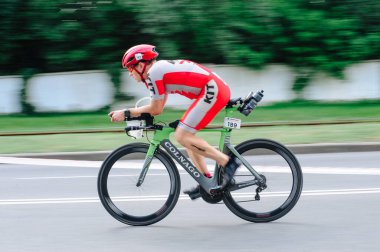 KHARKIV, UKRAINE - 2 Ağustos 2020 Demir Adam yarışması sırasında triatoncu bisikletli triatloncu bisikleti. Üç takım elbiseli ve kasklı bir bisiklet sporcusu. Halka açık etkinliklere izin var. CV salgını sırasında Avrupa sporu.