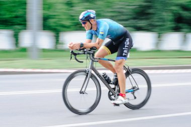 KHARKIV, UKRAINE - 2 Ağustos 2020 Demir Adam yarışması sırasında triatoncu bisikletli triatloncu bisikleti. Üç takım elbiseli ve kasklı bir bisiklet sporcusu. Halka açık etkinliklere izin var. CV salgını sırasında Avrupa sporu.