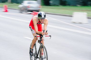 KHARKIV, UKRAINE - 2 Ağustos 2020 Demir Adam yarışması sırasında triatoncu bisikletli triatloncu bisikleti. Üç takım elbiseli ve kasklı bir bisiklet sporcusu. Halka açık etkinliklere izin var. CV salgını sırasında Avrupa sporu.