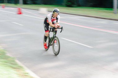 KHARKIV, UKRAINE - 2 Ağustos 2020 Demir Adam yarışması sırasında triatoncu bisikletli triatloncu bisikleti. Üç takım elbiseli ve kasklı bir bisiklet sporcusu. Halka açık etkinliklere izin var. CV salgını sırasında Avrupa sporu.