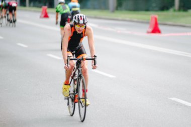 KHARKIV, UKRAINE - 2 Ağustos 2020 Demir Adam yarışması sırasında triatoncu bisikletli triatloncu bisikleti. Üç takım elbiseli ve kasklı bir bisiklet sporcusu. Halka açık etkinliklere izin var. CV salgını sırasında Avrupa sporu.