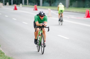 KHARKIV, UKRAINE - 2 Ağustos 2020 Demir Adam yarışması sırasında triatoncu bisikletli triatloncu bisikleti. Üç takım elbiseli ve kasklı bir bisiklet sporcusu. Halka açık etkinliklere izin var. CV salgını sırasında Avrupa sporu.