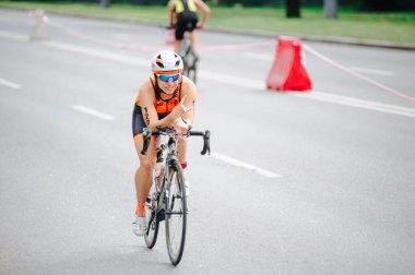 KHARKIV, UKRAINE - 2 Ağustos 2020 Demir Adam yarışması sırasında triatoncu bisikletli triatloncu bisikleti. Üç takım elbiseli ve kasklı bir bisiklet sporcusu. Halka açık etkinliklere izin var. CV salgını sırasında Avrupa sporu.