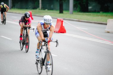 KHARKIV, UKRAINE - 2 Ağustos 2020 Demir Adam yarışması sırasında triatoncu bisikletli triatloncu bisikleti. Üç takım elbiseli ve kasklı bir bisiklet sporcusu. Halka açık etkinliklere izin var. CV salgını sırasında Avrupa sporu.