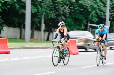 KHARKIV, UKRAINE - 2 Ağustos 2020 Demir Adam yarışması sırasında triatoncu bisikletli triatloncu bisikleti. Üç takım elbiseli ve kasklı bir bisiklet sporcusu. Halka açık etkinliklere izin var. CV salgını sırasında Avrupa sporu.