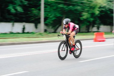 KHARKIV, UKRAINE - 2 Ağustos 2020 Demir Adam yarışması sırasında triatoncu bisikletli triatloncu bisikleti. Üç takım elbiseli ve kasklı bir bisiklet sporcusu. Halka açık etkinliklere izin var. CV salgını sırasında Avrupa sporu.
