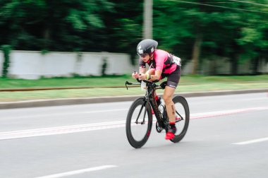 KHARKIV, UKRAINE - 2 Ağustos 2020 Demir Adam yarışması sırasında triatoncu bisikletli triatloncu bisikleti. Üç takım elbiseli ve kasklı bir bisiklet sporcusu. Halka açık etkinliklere izin var. CV salgını sırasında Avrupa sporu.