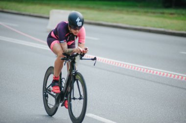 KHARKIV, UKRAINE - 2 Ağustos 2020 Demir Adam yarışması sırasında triatoncu bisikletli triatloncu bisikleti. Üç takım elbiseli ve kasklı bir bisiklet sporcusu. Halka açık etkinliklere izin var. CV salgını sırasında Avrupa sporu.