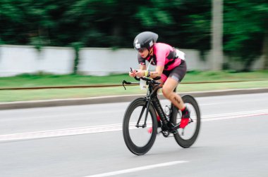 KHARKIV, UKRAINE - 2 Ağustos 2020 Demir Adam yarışması sırasında triatoncu bisikletli triatloncu bisikleti. Üç takım elbiseli ve kasklı bir bisiklet sporcusu. Halka açık etkinliklere izin var. CV salgını sırasında Avrupa sporu.