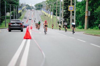 KHARKIV, UKRAINE - 2 Ağustos 2020 Demir Adam yarışması sırasında triatoncu bisikletli triatloncu bisikleti. Üç takım elbiseli ve kasklı bir bisiklet sporcusu. Halka açık etkinliklere izin var. CV salgını sırasında Avrupa sporu.