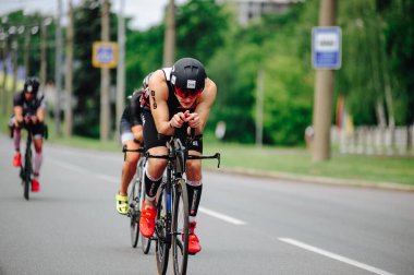 KHARKIV, UKRAINE - 2 Ağustos 2020 Demir Adam yarışması sırasında triatoncu bisikletli triatloncu bisikleti. Üç takım elbiseli ve kasklı bir bisiklet sporcusu. Halka açık etkinliklere izin var. CV salgını sırasında Avrupa sporu.