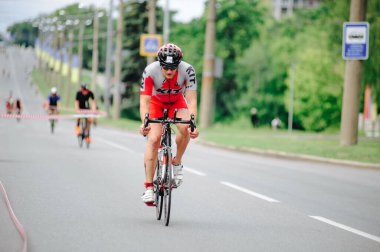 KHARKIV, UKRAINE - 2 Ağustos 2020 Demir Adam yarışması sırasında triatoncu bisikletli triatloncu bisikleti. Üç takım elbiseli ve kasklı bir bisiklet sporcusu. Halka açık etkinliklere izin var. CV salgını sırasında Avrupa sporu.