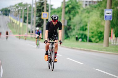KHARKIV, UKRAINE - 2 Ağustos 2020 Demir Adam yarışması sırasında triatoncu bisikletli triatloncu bisikleti. Üç takım elbiseli ve kasklı bir bisiklet sporcusu. Halka açık etkinliklere izin var. CV salgını sırasında Avrupa sporu.