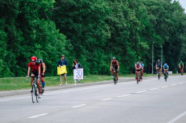 KHARKIV, UKRAINE - 2 Ağustos 2020 Demir Adam yarışması sırasında triatoncu bisikletli triatloncu bisikleti. Üç takım elbiseli ve kasklı bir bisiklet sporcusu. Halka açık etkinliklere izin var. CV salgını sırasında Avrupa sporu.