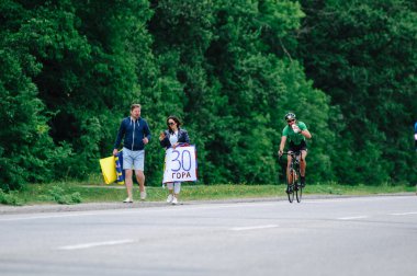 KHARKIV, UKRAINE - 2 Ağustos 2020 Demir Adam yarışması sırasında triatoncu bisikletli triatloncu bisikleti. Üç takım elbiseli ve kasklı bir bisiklet sporcusu. Halka açık etkinliklere izin var. CV salgını sırasında Avrupa sporu.