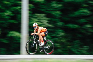 KHARKIV, UKRAINE - 2 Ağustos 2020 Demir Adam yarışması sırasında triatoncu bisikletli triatloncu bisikleti. Üç takım elbiseli ve kasklı bir bisiklet sporcusu. Halka açık etkinliklere izin var. CV salgını sırasında Avrupa sporu.