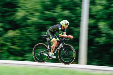 KHARKIV, UKRAINE - 2 Ağustos 2020 Demir Adam yarışması sırasında triatoncu bisikletli triatloncu bisikleti. Üç takım elbiseli ve kasklı bir bisiklet sporcusu. Halka açık etkinliklere izin var. CV salgını sırasında Avrupa sporu.