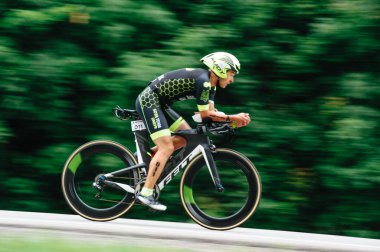 KHARKIV, UKRAINE - 2 Ağustos 2020 Demir Adam yarışması sırasında triatoncu bisikletli triatloncu bisikleti. Üç takım elbiseli ve kasklı bir bisiklet sporcusu. Halka açık etkinliklere izin var. CV salgını sırasında Avrupa sporu.