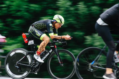 KHARKIV, UKRAINE - 2 Ağustos 2020 Demir Adam yarışması sırasında triatoncu bisikletli triatloncu bisikleti. Üç takım elbiseli ve kasklı bir bisiklet sporcusu. Halka açık etkinliklere izin var. CV salgını sırasında Avrupa sporu.