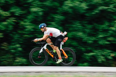 KHARKIV, UKRAINE - 2 Ağustos 2020 Demir Adam yarışması sırasında triatoncu bisikletli triatloncu bisikleti. Üç takım elbiseli ve kasklı bir bisiklet sporcusu. Halka açık etkinliklere izin var. CV salgını sırasında Avrupa sporu.