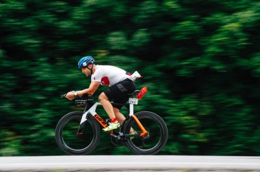 KHARKIV, UKRAINE - 2 Ağustos 2020 Demir Adam yarışması sırasında triatoncu bisikletli triatloncu bisikleti. Üç takım elbiseli ve kasklı bir bisiklet sporcusu. Halka açık etkinliklere izin var. CV salgını sırasında Avrupa sporu.